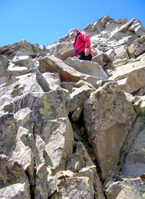 Gerry carefully negotiating the air-filled setups of interlaced, loose blocks between the deep notch and the summit