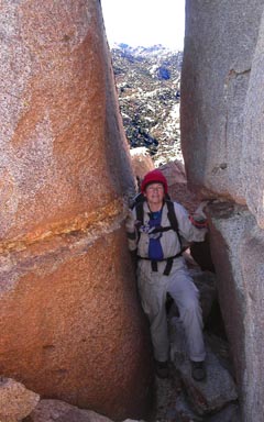 Jennifer squeezing through a tight passage below the summit block