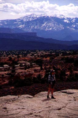 The La Sal Mountains watch Jennifer on top of Broken Arch